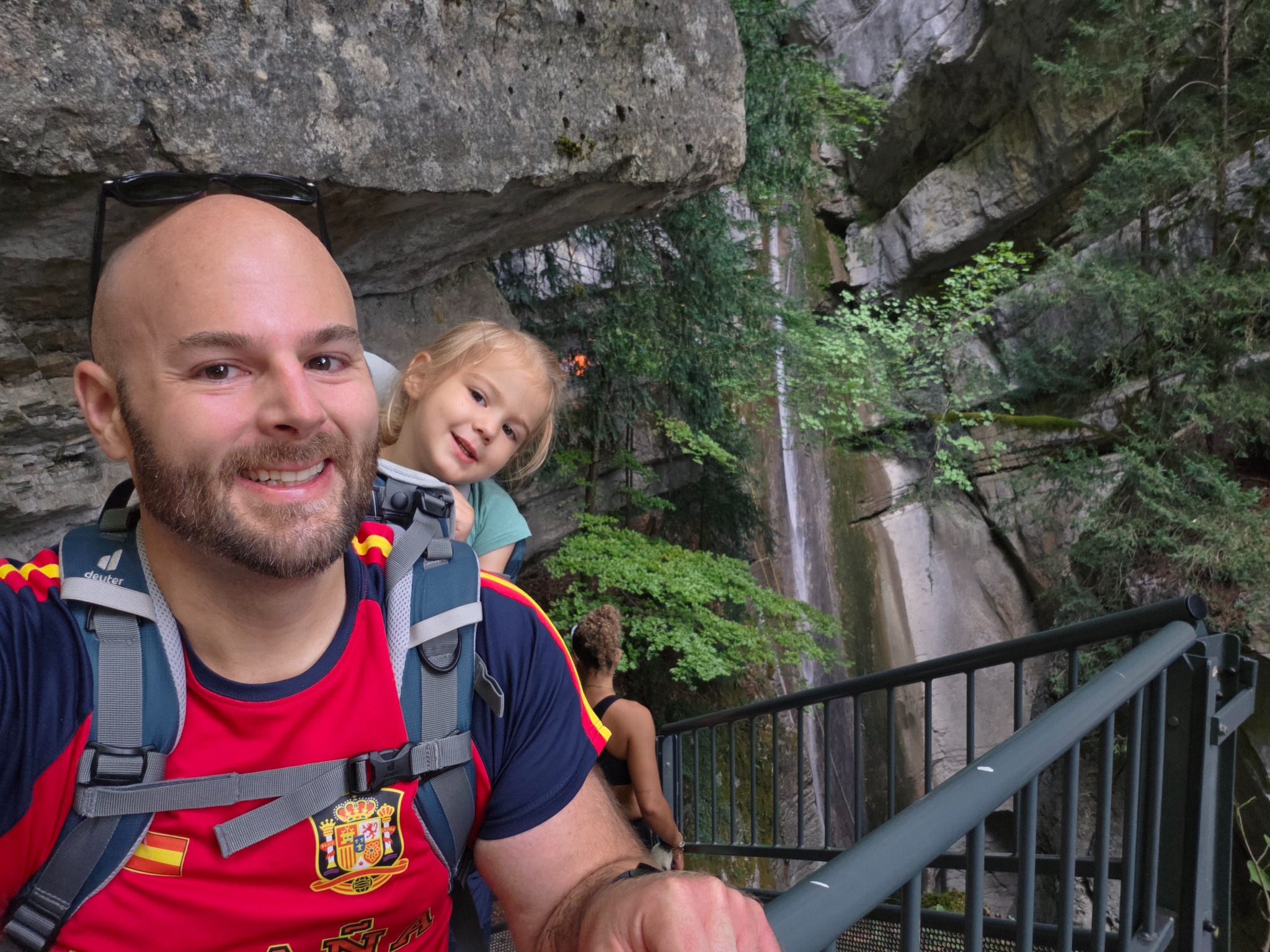 Andrew Nelson hiking with his child beside a waterfall